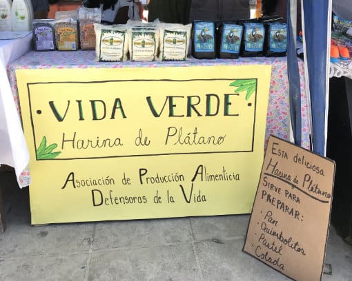 Plantain Flour For Sale A table at a market with plantain flour and coffee for sale; the sign reads: "Vida Verde, Harina de Platano", Asociación de Producción Alimenticia Defensoras de la Vida